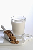 Glass of milk and small scoop full of almonds