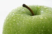 Green apple with drops of water (close-up)