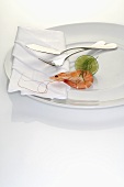 Prawn and lime on plate with napkin and cutlery