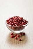 Red peppercorns in a small glass dish