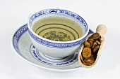 Bowl of tea with corydalis root in a wooden scoop