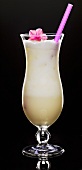 Sahne-Cocktail mit einer Blüte und Strohhalm