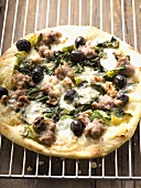 Pizza with mince, olives, spinach and cheese