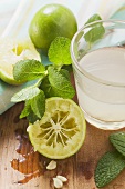 Lime juice in glass, limes and fresh mint