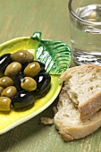 Olives, white bread and glass of water