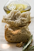 Pieces of white bread on linen cloth with olive sprig, olive oil