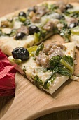 Pizza with tuna, chard and olives, a slice cut