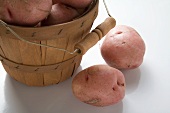 Red potatoes in and beside woodchip basket