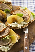 Open sandwiches of duck breast and apple on wooden board