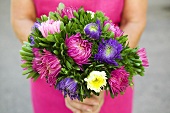 Woman holding bunch of summer flowers