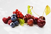 Assorted berries and three cherries with leaves