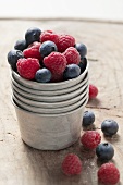 Raspberries and blueberries in metal container
