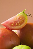 Wedge of tomato on whole tomatoes