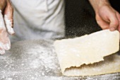 Sprinkling pasta dough with flour