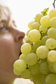 Woman eating fresh green grapes