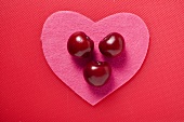 Three cherries on a pink felt heart