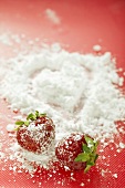 Two strawberries with icing sugar