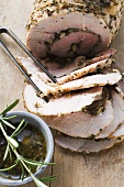Rolled pork roast with herbs, partly carved