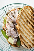 Toasted bread topped with pork and salad