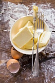Butter in basin, eggshells, pastry brush and fork