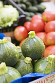 Round courgettes in a crate at a market