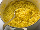 Saffron risotto in pan with spoon