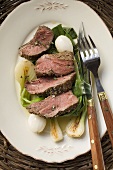 Beef steak, sliced, with roasted spring onions