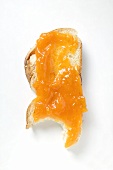 Slice of bread plait with apricot jam, a bite taken