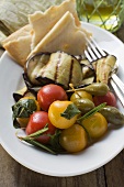 Grilled aubergines with cherry tomatoes, capers, flatbread