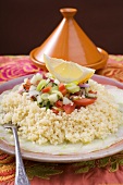 Couscous on cucumber slices with onions, leeks and peppers