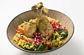 Chicken legs with saffron rice and pomegranate seeds