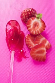 Ein Löffel Erdbeermarmelade, daneben frische Erdbeeren