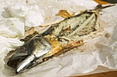 Remains of Steckerlfisch (skewered fish) on paper