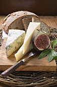 Various types of cheese, bread and half a fig
