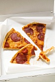 Three slices of pepperoni pizza in pizza box