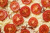 Pizza mit Tomaten und Käse (ungebacken), bildfüllend