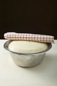Leaving pizza dough to rest in bowl