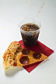 Slice of American-style pepperoni pizza with cola