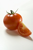 Whole tomato and a wedge of tomato