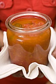 Hands holding preserving jar of tomato sauce