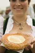 Woman holding Auszogene (Bavarian fried pastry) on napkin