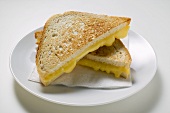 Toasted cheese sandwiches on paper napkin on white plate