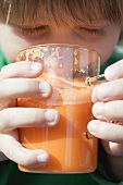 Child drinking a glass of carrot juice