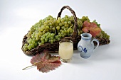 Green grapes in basket, grape must and leaves