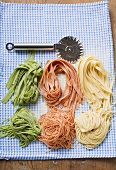 Various types of home-made pasta with pastry wheel