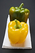 Two peppers (yellow, green) on white linen cloth