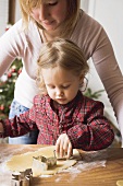 Mother and child cutting out Christmas biscuits