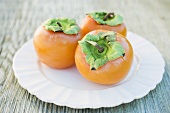 Three Sharon fruits on white plate