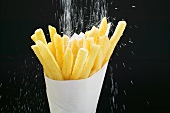 Sprinkling salt on chips in paper cone