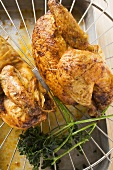 Two half roast chickens on rack above roasting tin